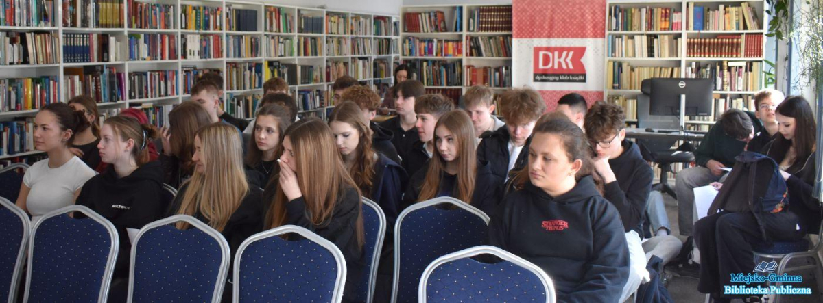 Młodzież siedzi na oraz czyta tekst