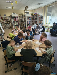 Dzieci siedzą przy stolikach