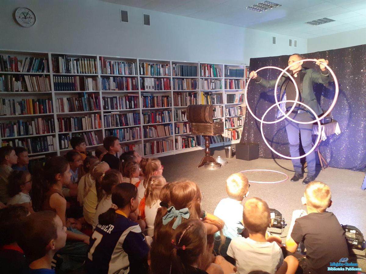 dzieci siedzą a Pan trzyam hula hop