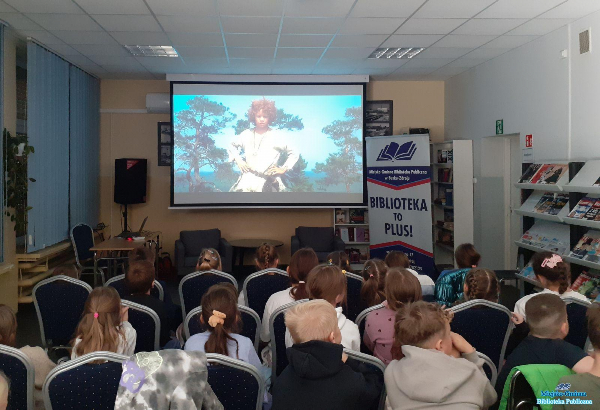 Najmłodsi siedzą  i oglądają seans filmowy