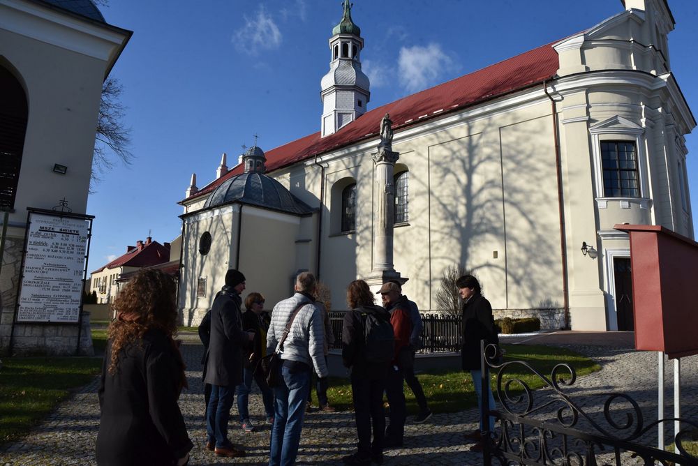 Dziewięć osób stoi przed kościołem