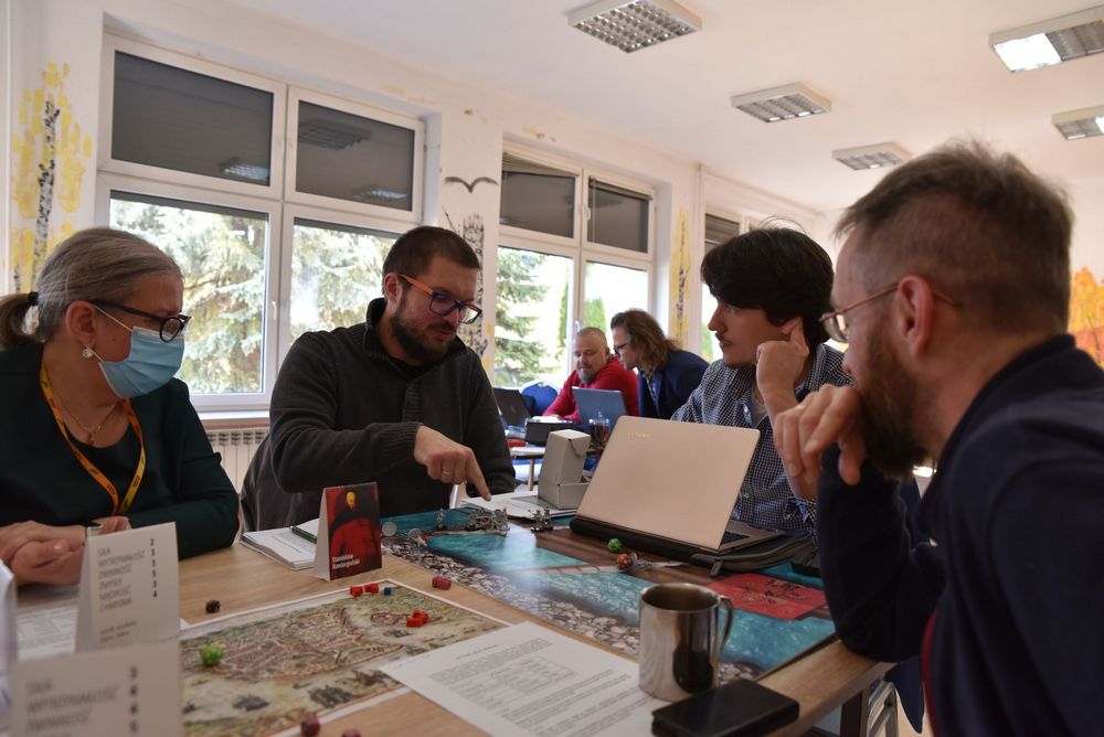 Osoby dyskutują nad rozgrywką planszówkową