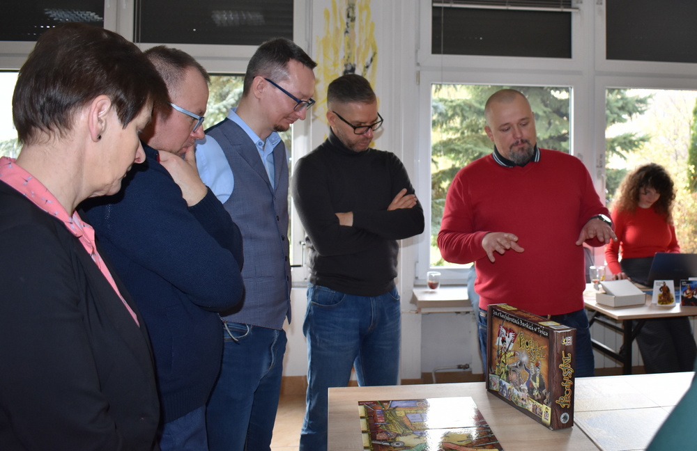 Pięć osób prowadzi dyskusję na temat gry planszowej