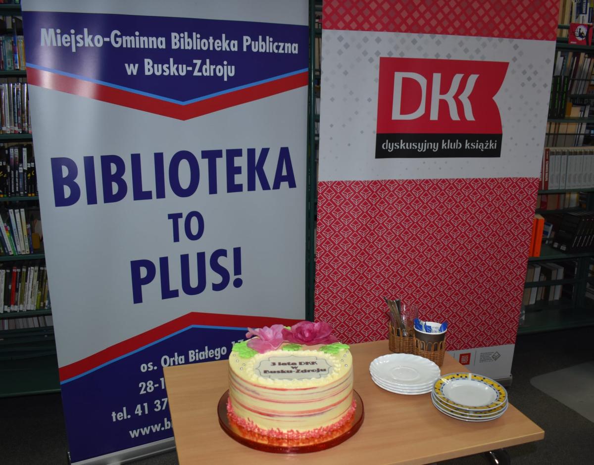 Tort stoi na stoliku na tle banerów 