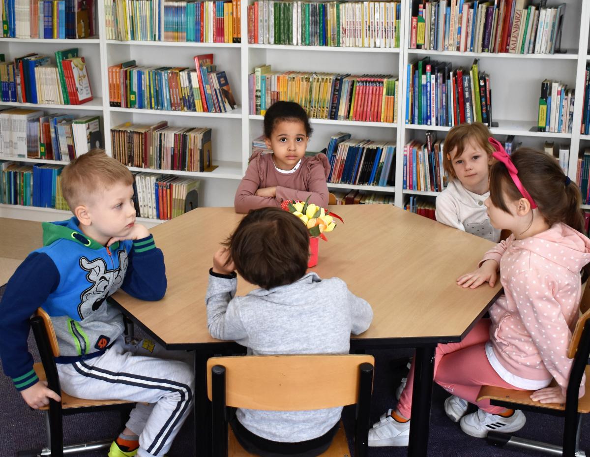 Pięcioro dzieci siedzi przy stoliku