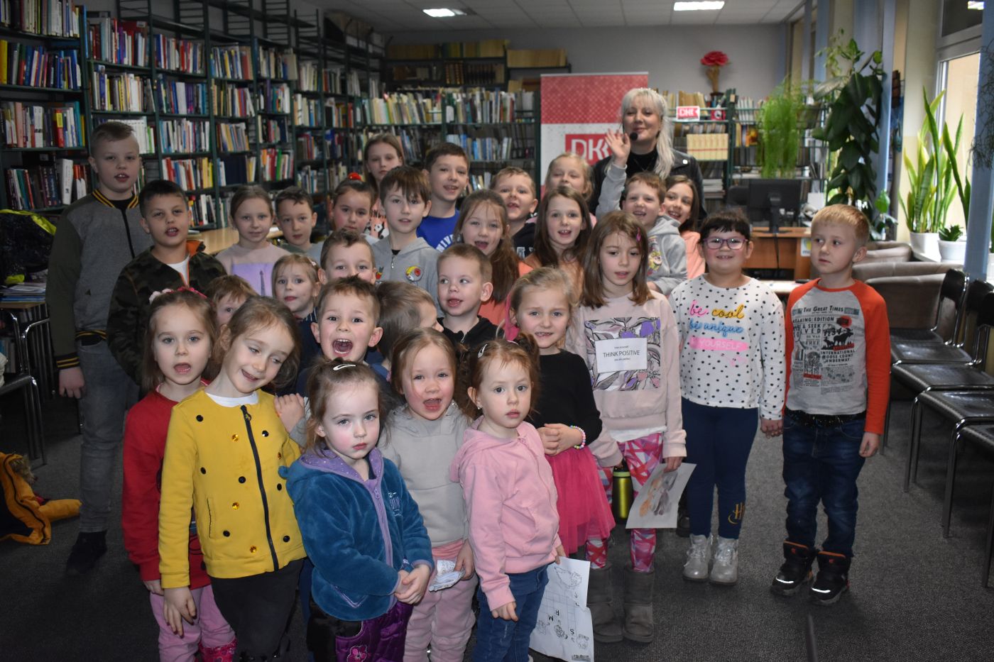 Grupa dzieci pozuje do zdjęcia z Panią Moniką Sawicką