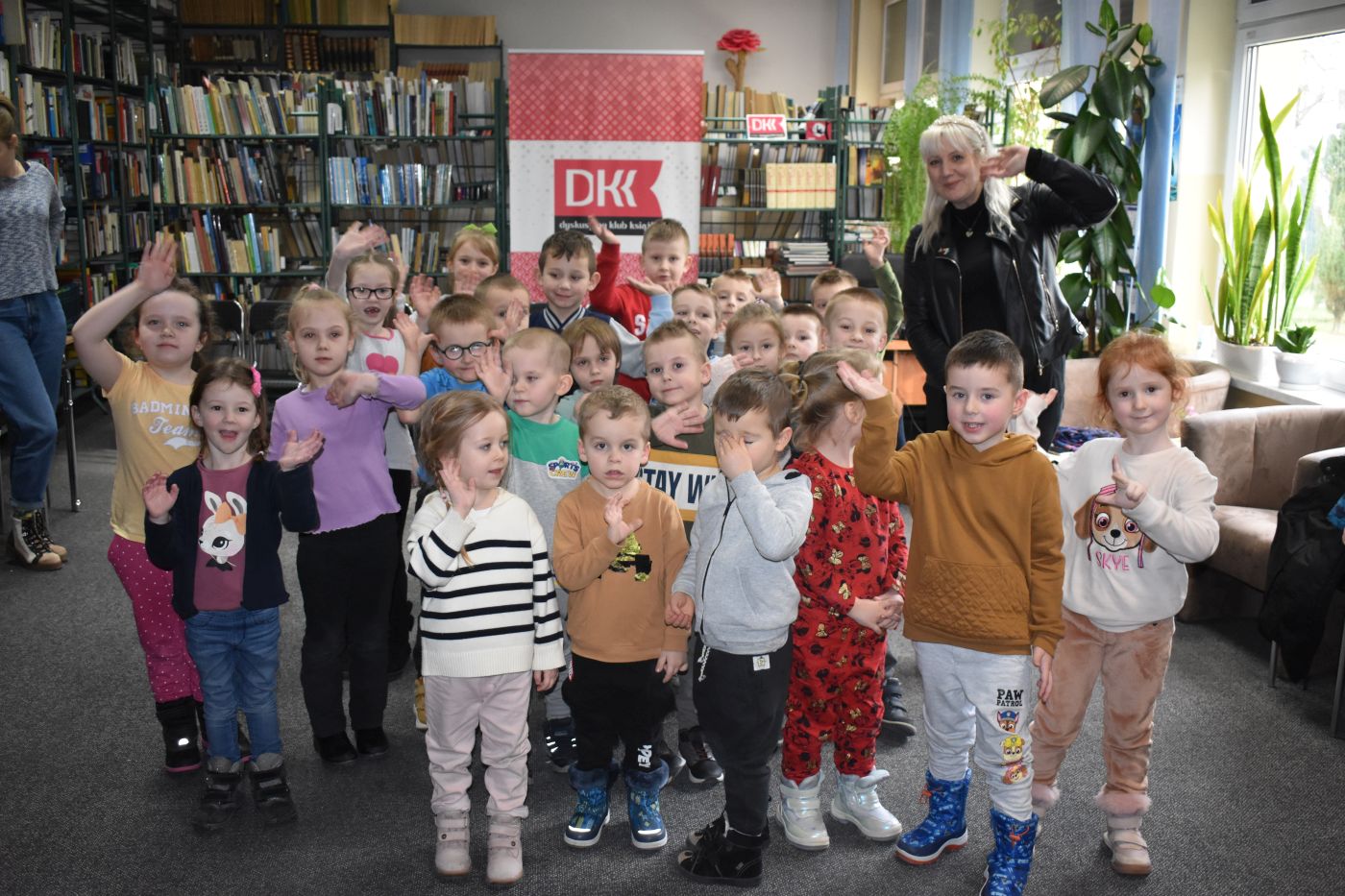 Grupa dzieci pozuje do zdjęcia z Panią Moniką Sawicką