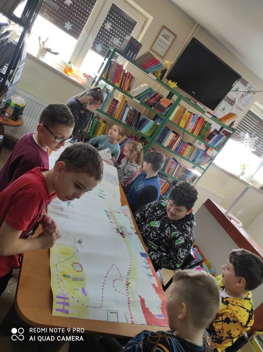 Grupa dzieci siedzi przy stoliku
