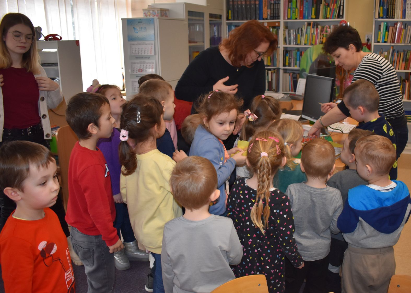 Dzieci z Paniami stoją przy biurku