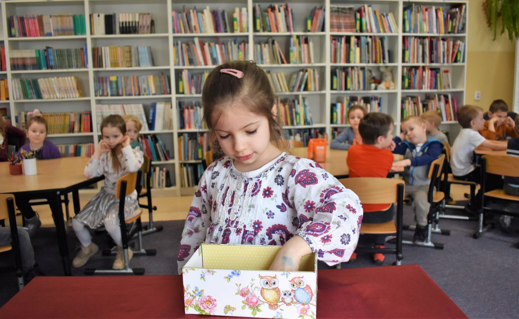 Dziewczynka losuje pytanie z pudełeczka