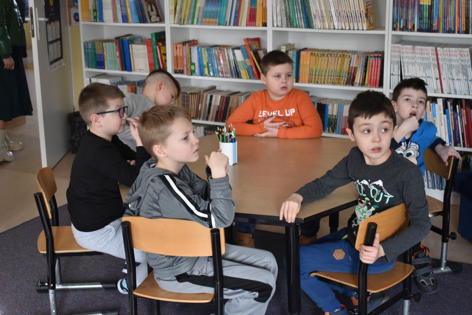 Grupa chłopców siedzi przy stoliku