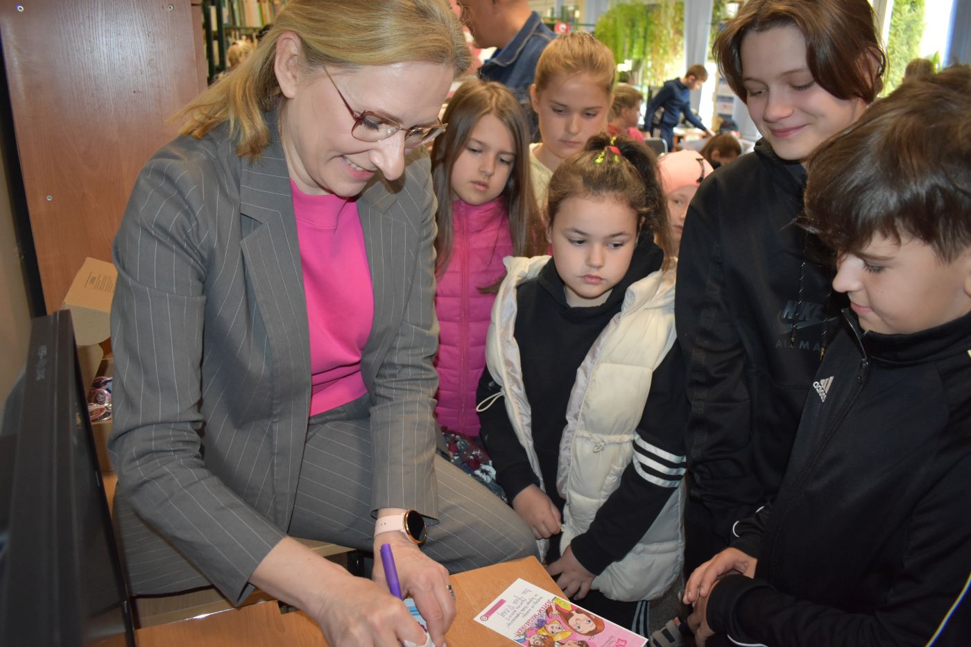 Autorka książek rozdaje autografy