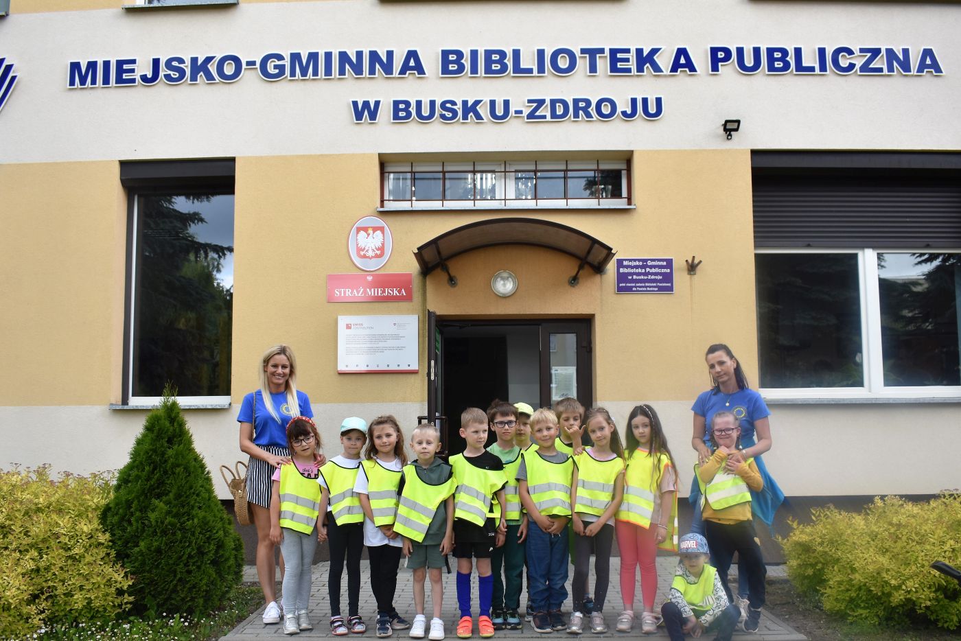 Grupa dzieci przed budynkiem biblioteki