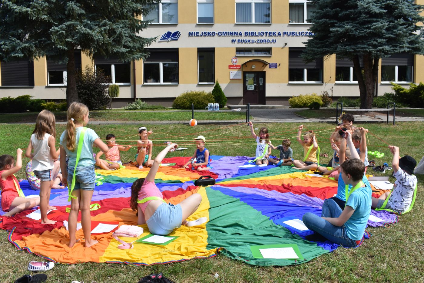 Dzieci podnoszą ręce do góry trzymając w dłoniach sznurek