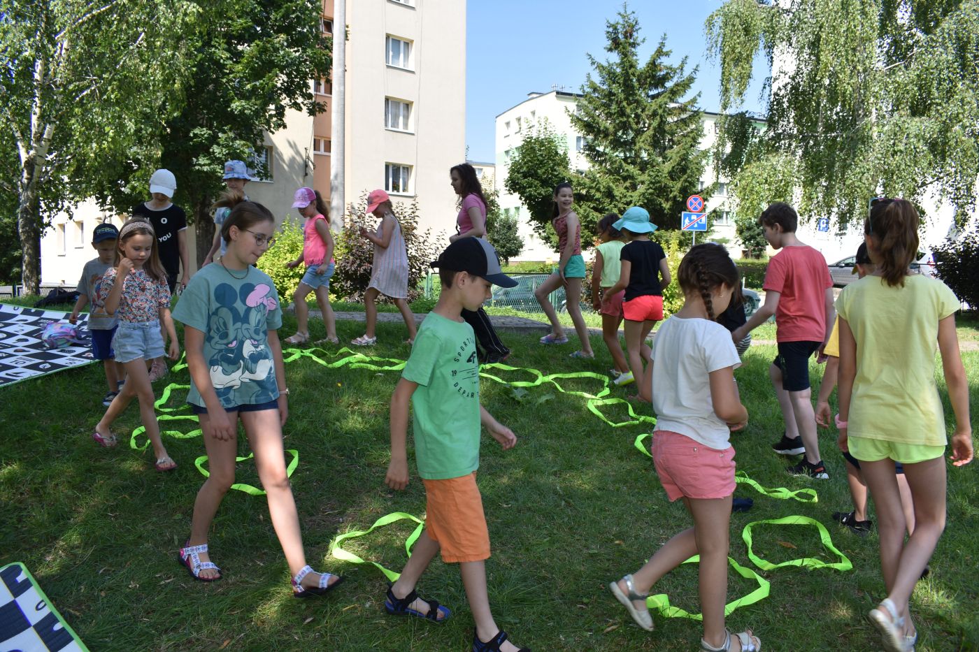dzieci chodzą wokół szarf położonych na trawie
