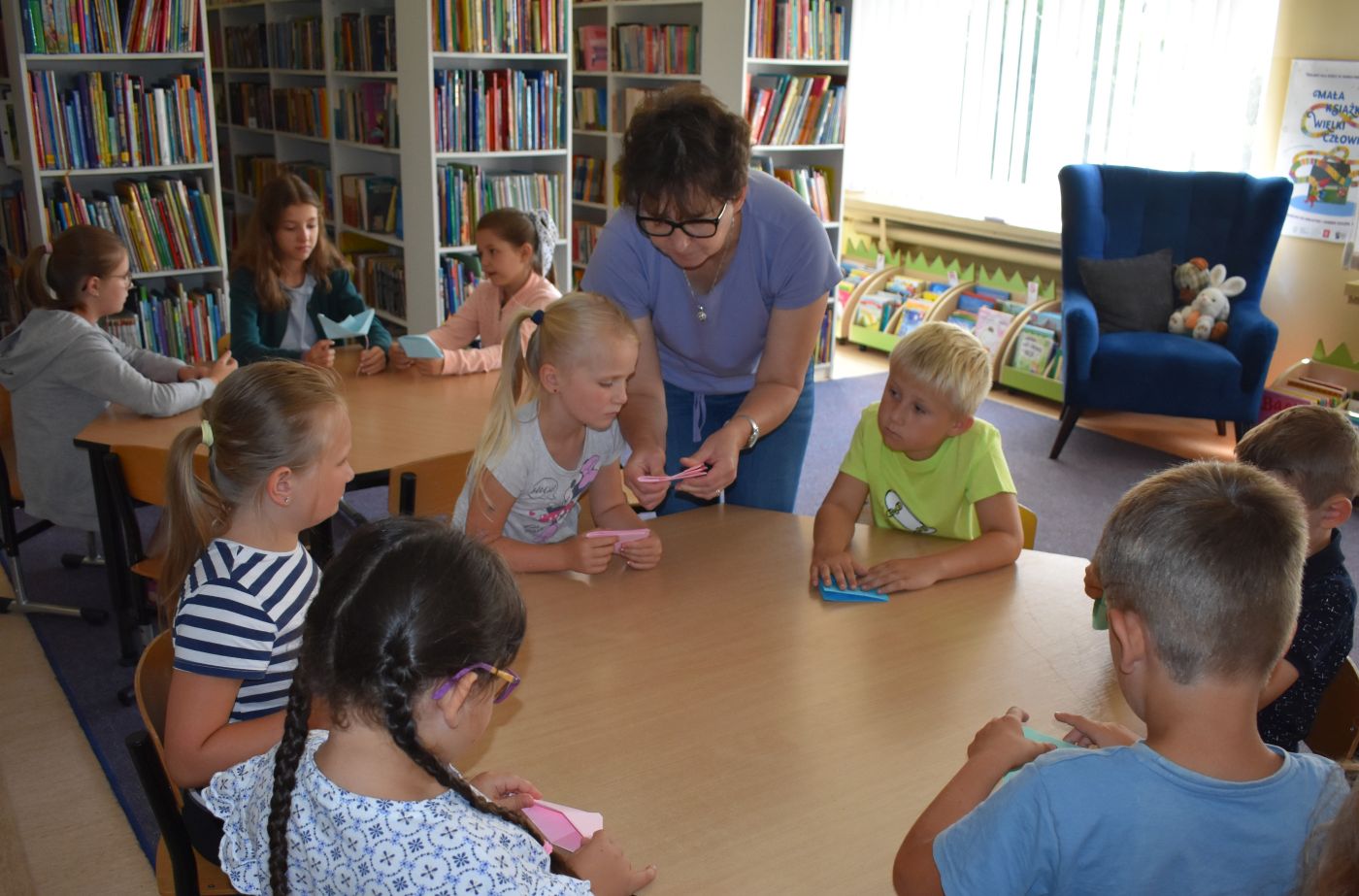 pani z dziećmi pracuje przy stoliku