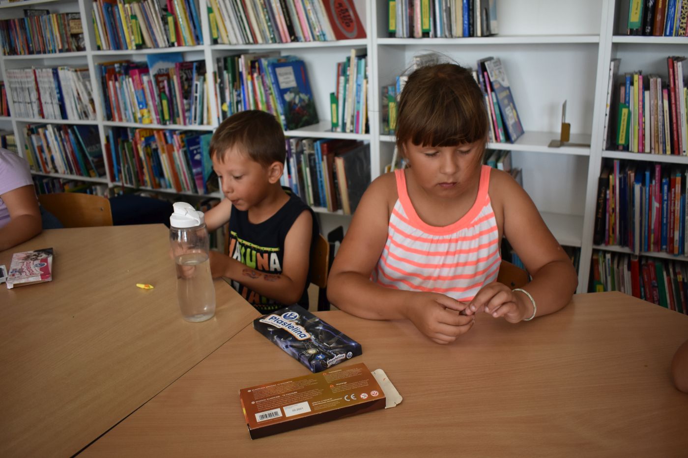 Dziewczynka i chłopiec lepią figury z plasteliny