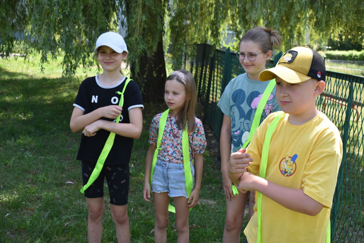 czwórka dzieci z szarfami słucha pani