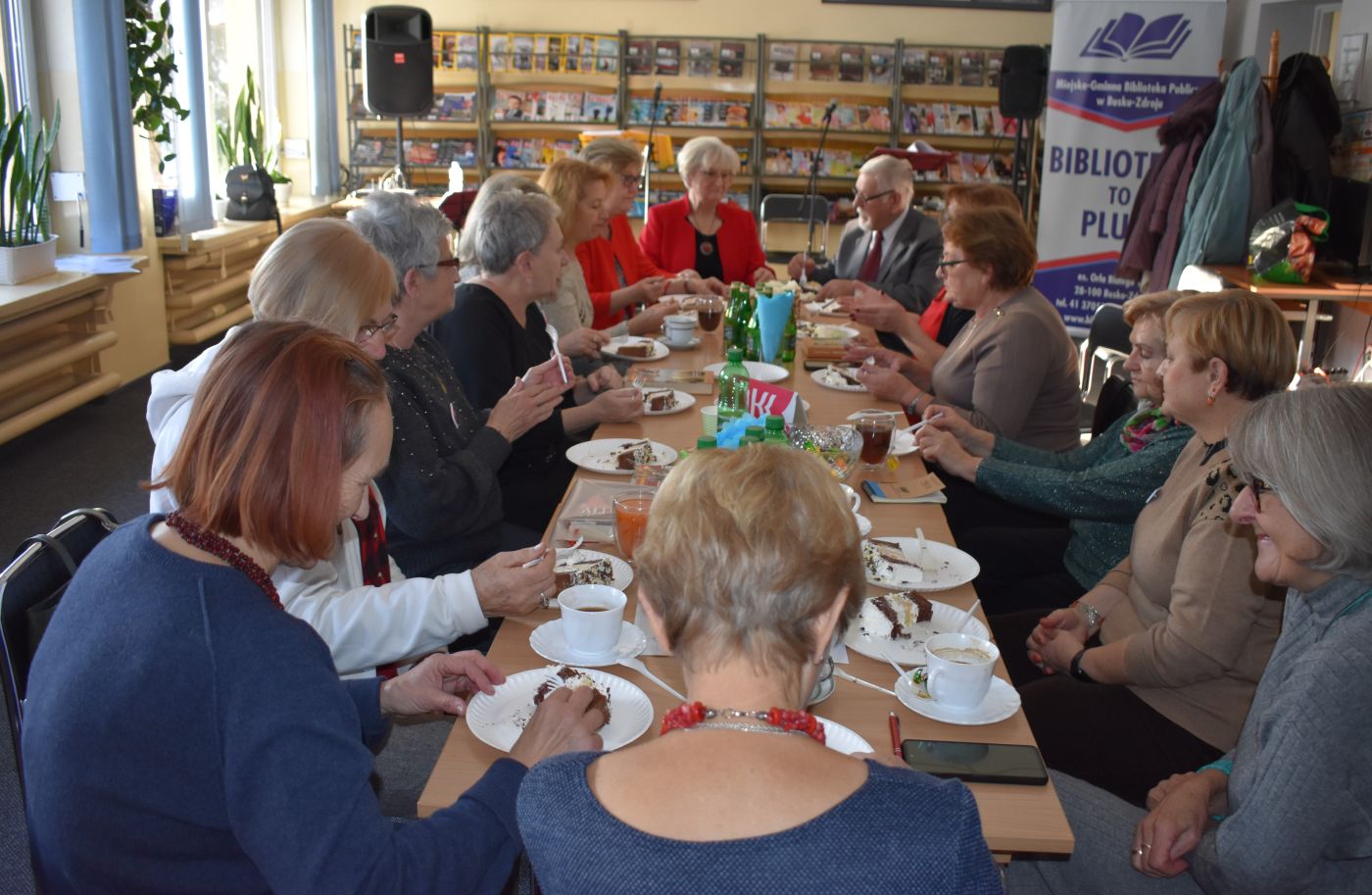 Zgromadzeni uczestnicy spotkania siedzą przy wspólnym stole