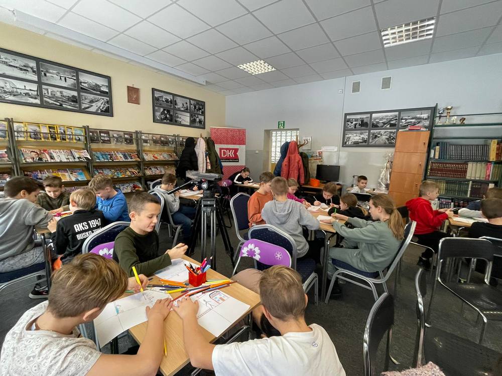 Dzieci przy stolikach rysują komiksy
