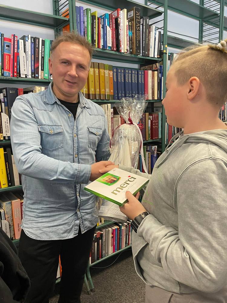 Dzieci wręczają Zbigniewowi Masternakowi prezent i dziękują za spotkanie