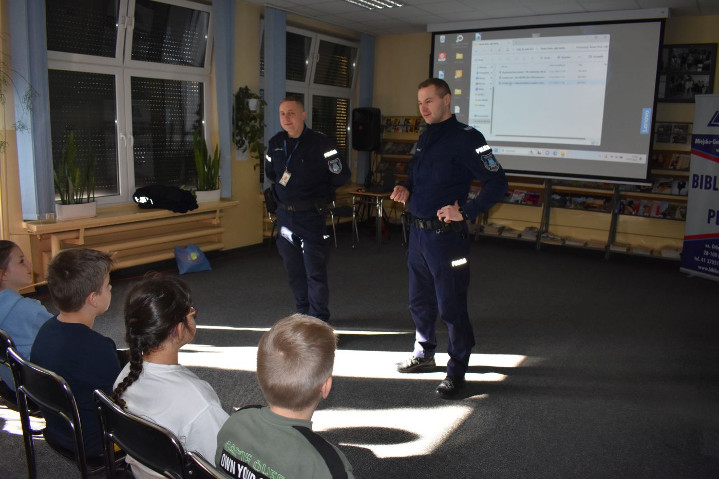 dwóch policjantów rozmawia z dziećmi