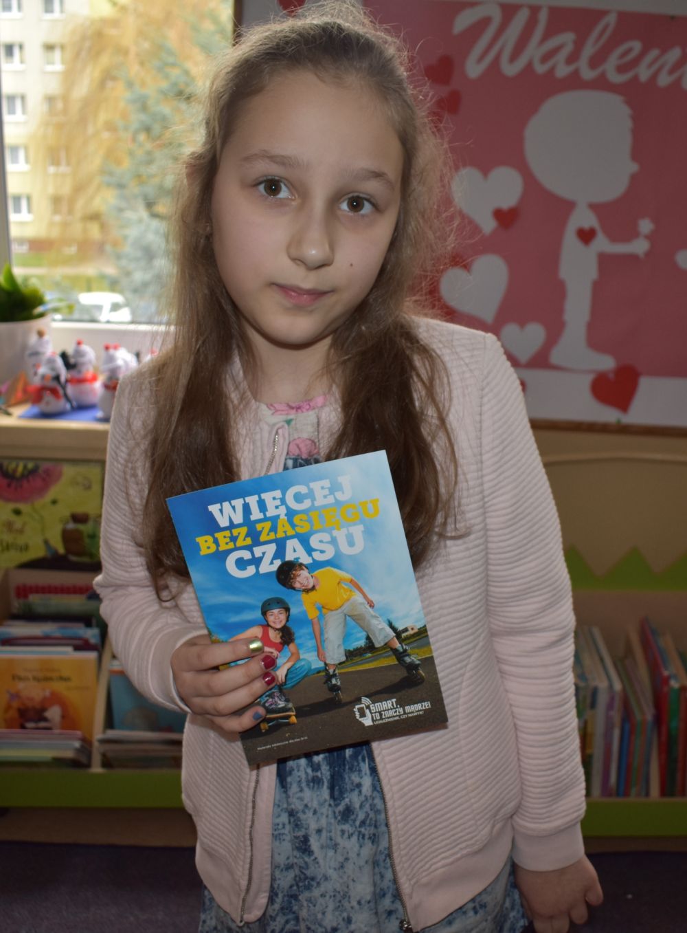 dziewczynka prezentuje broszurkę informacyjna