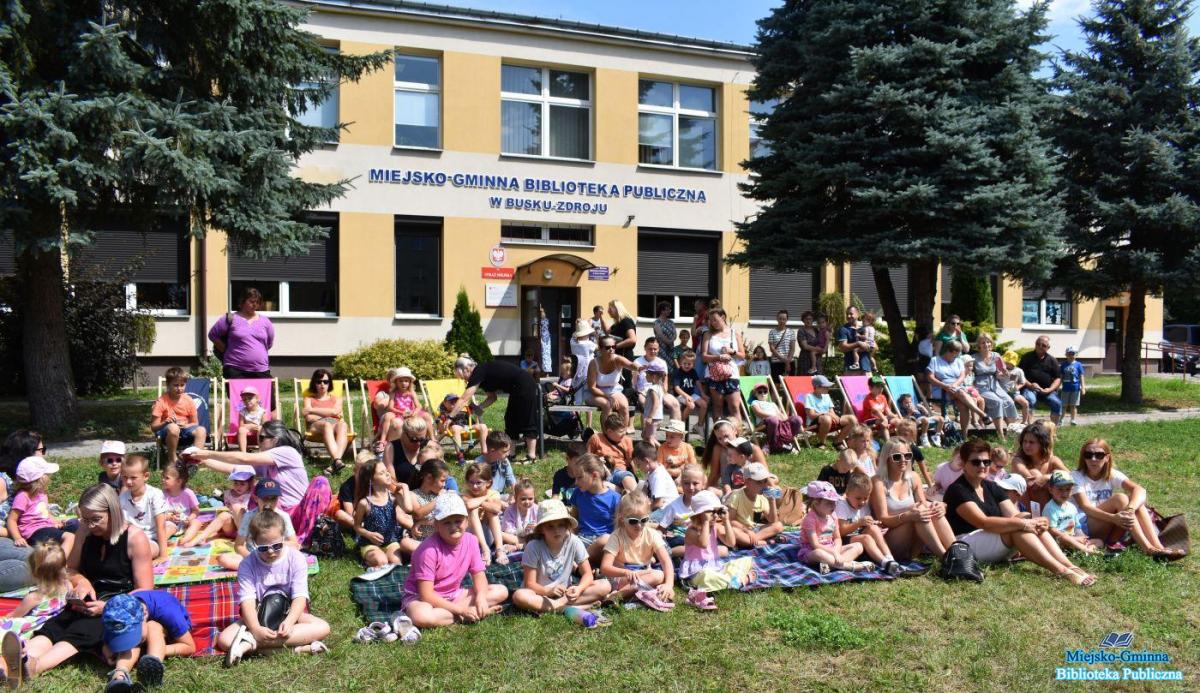 dzieci siedzę przed biblioteka