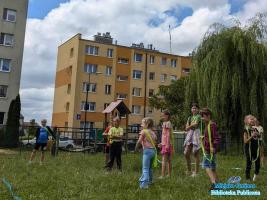 Grupa dzieci bawi się na trawie