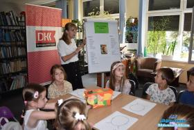 Pani psycholog mówi do dzieci, obok niej karta na której są wypisane wady i zalety Ani z Zielonego Wzgórza.
