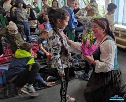 Dziewczynka wręcza kwiaty pani prowadzącej wykład
