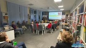 Grupa osób ogląda prezentację i słucha wykładu