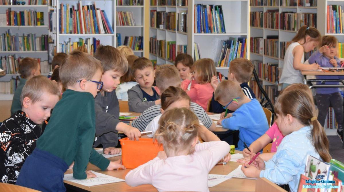 Dzieci siedzą przy stolikach