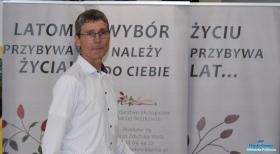Pan stoi na tle banerów