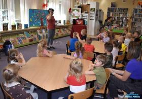 Pani pokazuje dzieciom kartę biblioteczną