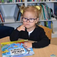 Małą dziewczynka siedzi z książką