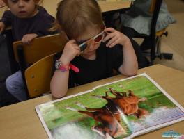 dziewczynka w okularach 3 D ogląda książkę