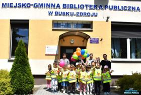 Dzieci pozują do zdjęcia przed budynkiem biblioteki