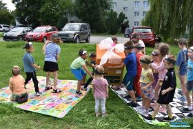 Dzieci wspólnie niosą wielkie pudło