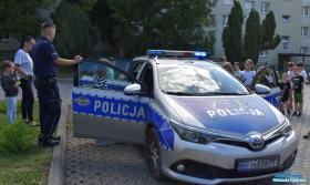 Pan policjant z dziećmi przy radiowozie