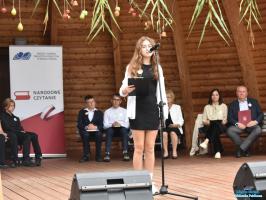 Dziewczynka z długimi włosami bierze udział w narodowym czytaniu