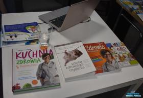 Książki i laptop leżą na stoliku