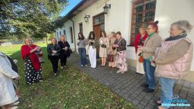 Grupa pań przed jasnym zabytkowym budynkiem