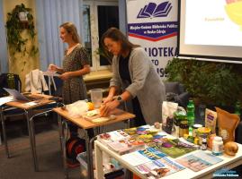 Jedna Pani stoi, druga kroi owoce