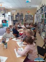 dzieci siedzą przy stolikach