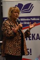 Pani trzyma mikrofon a drugą dłonią gestykuluje