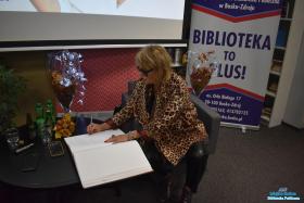 Pani wpisuje się do kroniki biblioteki