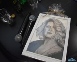 Portret Pani w ramce leży na stoliku a obok dwa mikrofony