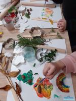 na stoliku leżą prace z gliny i gipsu ozdobione żołędziami i szyszkami