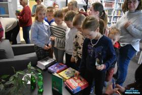 Dzieci stoją przed stolikiem, na którym leżą książki